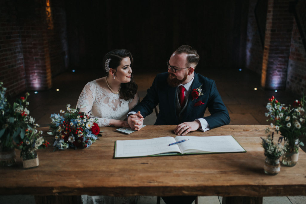vintage bride and groom signing the register 
