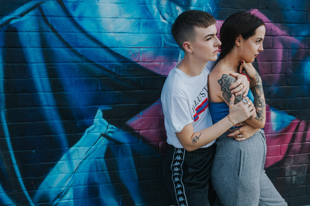 same sex couple photographed against graffiti in shorditch