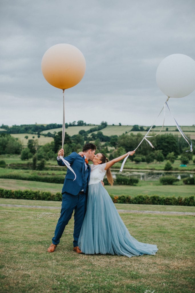 bride and groom with giant balloons at the Yorkshire wedding barn