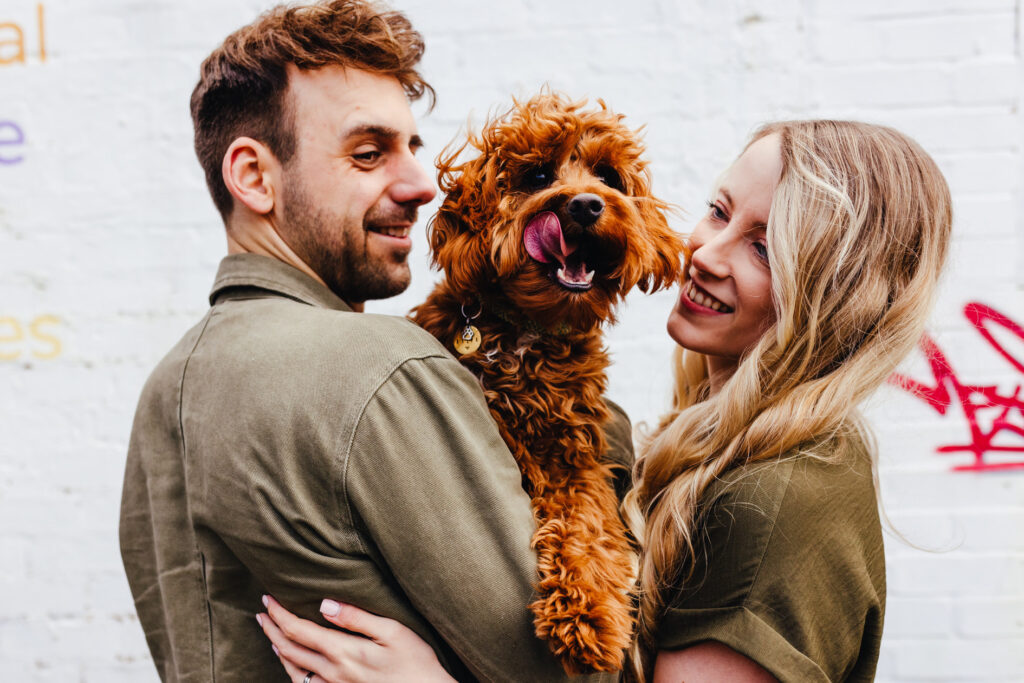 relaxed engagement photograph with couples dog against colourful graffiti at Digbeth, Birmingham.